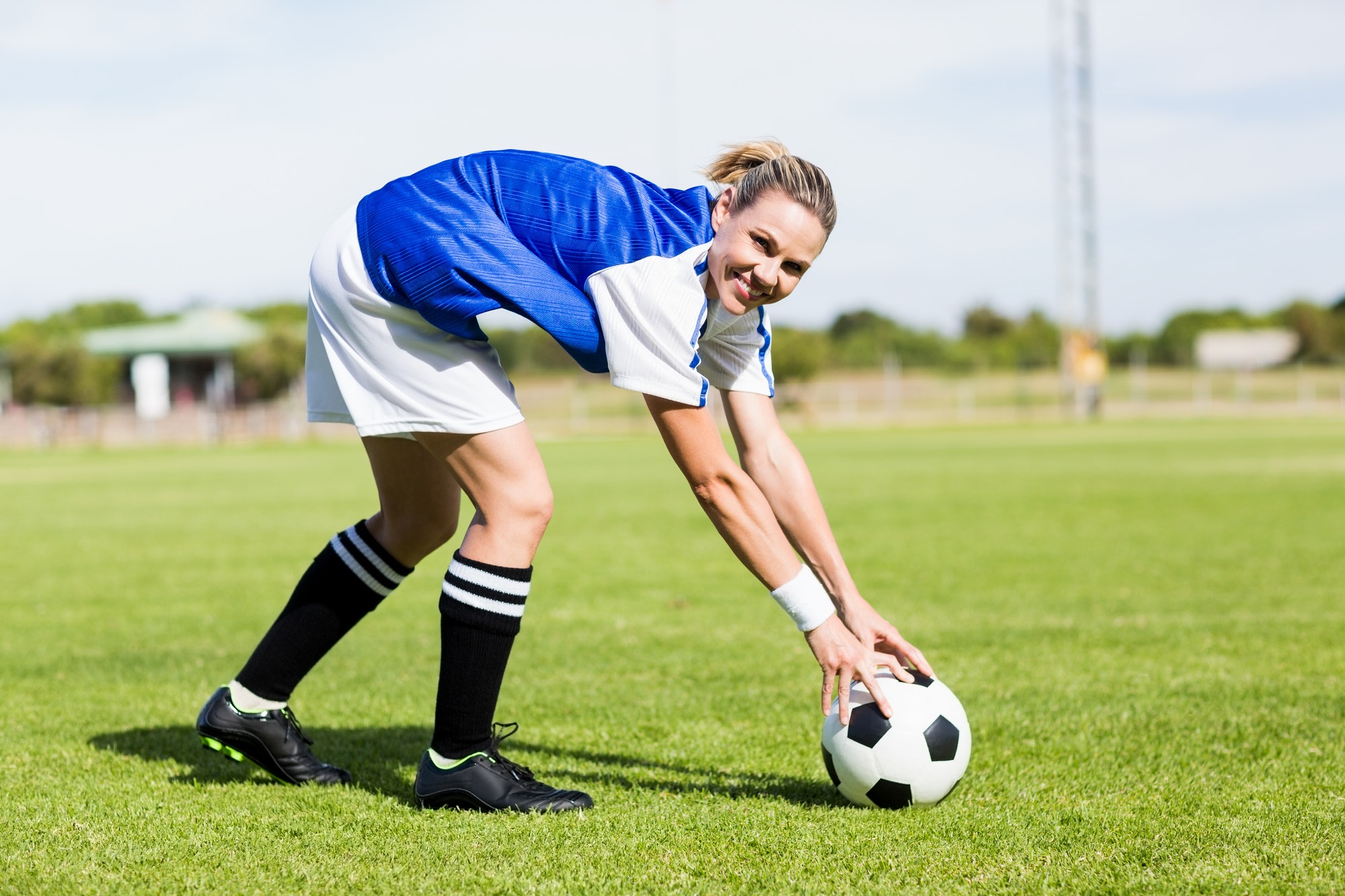 Portrait of female football player keeping a ball